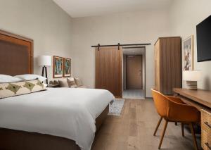 サンアントニオにあるPlaza San Antonio Hotel & Spa, Autograph Collectionの大きなベッドとデスクが備わるホテルルームです。