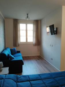 a living room with a blue couch and a window at B&B LA VALLUNA in Erbusco