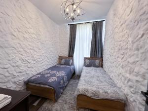 a bedroom with two twin beds and a chandelier at Qafqaz Suite Family Villa in Gabala