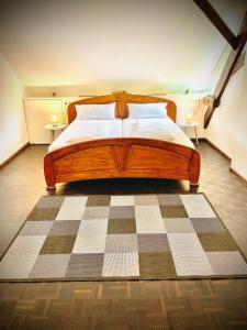 1 dormitorio con cama de madera y suelo a cuadros en Chris & Aris Ferienwohnung Waldshut Zentrum en Waldshut-Tiengen