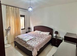 1 dormitorio con cama, lámpara y ventana en 4 Bedroom Flat in Madaba with AC en Madaba