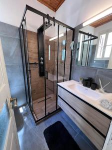 ein Bad mit einer Dusche und einem Waschbecken in der Unterkunft Neoclassical manor house in Poros