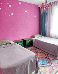 a bedroom with two beds and a pink wall at Hânetül Mabeyn in Rize