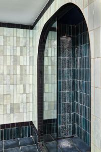 y baño con ducha y pared de azulejos. en The Manchester Hotel en Lexington