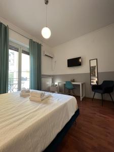 una camera con letto, scrivania e TV di Dante Suites a Palermo