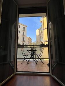 un patio con tavolo e sedie sul balcone. di Dante Suites a Palermo