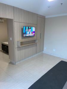 ein Wohnzimmer mit einem Flachbild-TV an der Wand in der Unterkunft Piazza diRoma com acesso ao Acqua Park e Splash in Caldas Novas