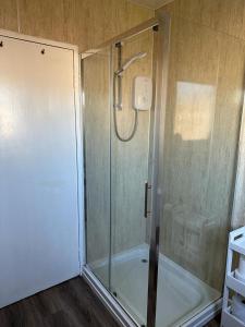 a shower with a glass door in a bathroom at Nithsdale Hotel in Sanquhar