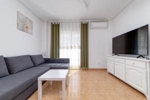 a living room with a couch and a flat screen tv at Penthouse CORBETA SUN in Torrevieja