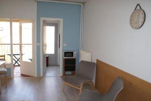 une chambre avec une chaise et un réveil sur le mur dans l'établissement Studio Soleil Vernet, à Vernet-les-Bains