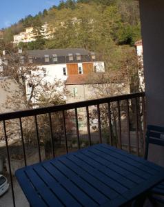 a blue picnic table on a balcony with a building at Studio Soleil Vernet in Vernet-les-Bains
