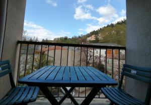 uma mesa de piquenique azul e 2 cadeiras numa varanda em Studio Soleil Vernet em Vernet-les-Bains