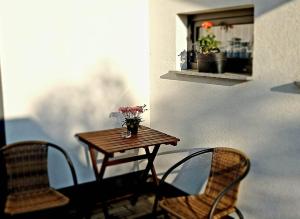 uma mesa com flores numa varanda com duas cadeiras em Casa Blanca Apartman em Balatonfenyves