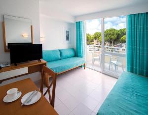 un soggiorno con divano blu e balcone di Club Hotel Cala Ratjada a Cala Ratjada