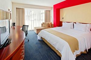 a hotel room with a bed and a flat screen tv at Holiday Inn Express Guadalajara Expo, an IHG Hotel in Guadalajara
