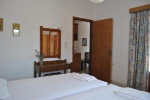 a bedroom with two beds and a mirror and a desk at Antigoni Apartments 'Lavender Room' in Milatos