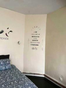 a bedroom with a bed and words on the wall at Appartement de 2 chambres avec wifi a Givet in Givet