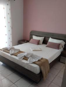 a bedroom with a large bed with white sheets and pillows at Ta Kavourakia in Mikros Gialos