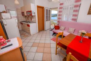 eine Küche und ein Wohnzimmer mit einem Tisch und einem Kühlschrank in der Unterkunft Apartments Sopic in Rogoznica