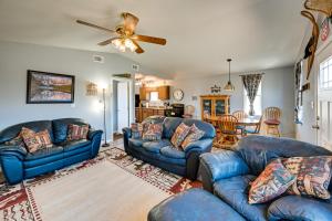 sala de estar con sofás azules y ventilador de techo en Kingman Vacation Rental with Private Yard and Fire Pit en Kingman