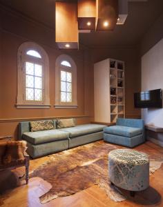 a living room with a couch and a tv at Ambit Boulevard Hotel Boutique in Santa Fe