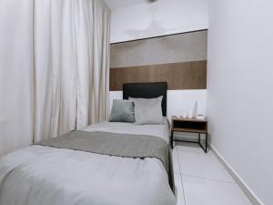 a bedroom with a bed and a side table at Skydeck with KL City View Cozy 2 Bedroom in KL in Kuala Lumpur