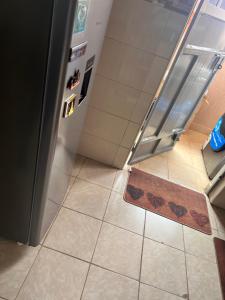 pusta kuchnia z lodówką i podłogą wyłożoną kafelkami w obiekcie B’s homely w mieście Ruiru