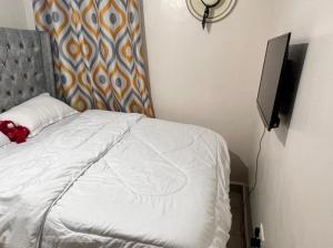 a bedroom with a bed and a flat screen tv at B’s homely in Ruiru