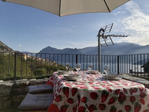 a table with wine glasses on top of a balcony at Casa Sasso in Tavernola Bergamasca