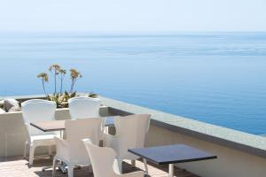 una mesa y sillas en un balcón con vistas al agua en Sea Breeze Retreat, en Cap d'Ail