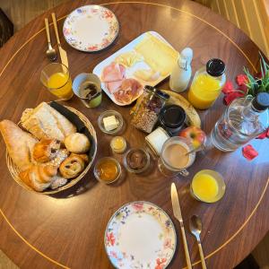 una mesa de madera con alimentos para el desayuno y bebidas. en les Refuges du Chalet, en Sart-lez-Spa