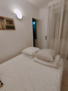 Coggia的住宿－Nico corse sagone，一张带白色床单和枕头的床