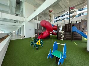 une salle de jeux avec une aire de jeux avec un toboggan dans l'établissement Family Duplex Penthouse 3 Bedroom The Wave Residence 8-9pax, à Malacca