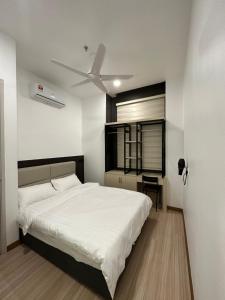 une chambre avec un lit blanc et un ventilateur de plafond dans l'établissement Family Duplex Penthouse 3 Bedroom The Wave Residence 8-9pax, à Malacca