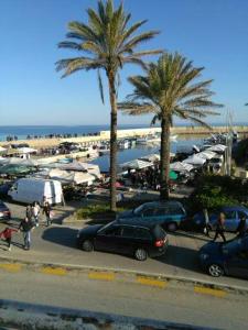 a parking lot with cars and palm trees and a beach at Casa Sofia: comodi e tranquilli in Maruggio