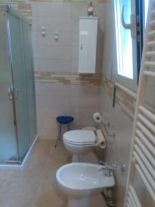 a bathroom with a toilet and a sink and a shower at Casa Sofia: comodi e tranquilli in Maruggio