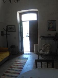a living room with a door open to a room at Casa Sofia: comodi e tranquilli in Maruggio