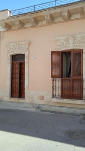 a white building with two windows and a door at Casa Sofia: comodi e tranquilli in Maruggio
