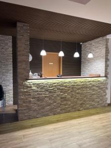 a bar in a room with a stone wall at Hotel Rosengarten in Frankfurt/Oder