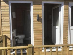 a bathroom with a toilet on a log house at Beacon House Bunks in Bridlington