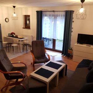 ein Wohnzimmer mit einem Sofa, Stühlen und einem Tisch in der Unterkunft Osada nad Potokiem in Szczyrk