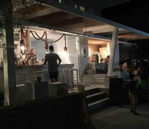 a man standing at the counter of a restaurant at night at Apartment with sea view in Pefkohori. in Pefkohori