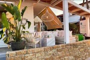 a patio with a couch and chairs on a porch at Apartment with sea view in Pefkohori. in Pefkohori