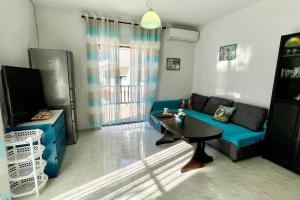 a living room with a blue couch and a table at Apartment with sea view in Pefkohori. in Pefkohori
