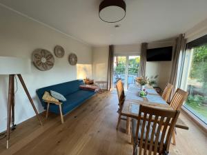 un salon avec un canapé bleu et une table dans l'établissement Ferienhaus "Haus am See", à Prenzlau