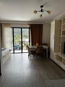 een woonkamer met een eettafel en een slaapkamer bij Vitali Apartment in Borjomi