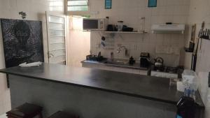 uma cozinha com um balcão e um lavatório em Hostel de Luz - Unidade 1 em Campinas