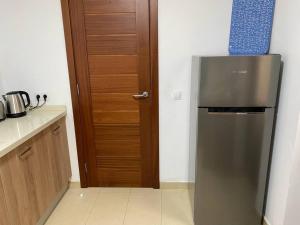 a kitchen with a stainless steel refrigerator and a wooden door at Casa Marla mit 3 Schlafzimmern und 2 Badezimmern in Puerto Calero