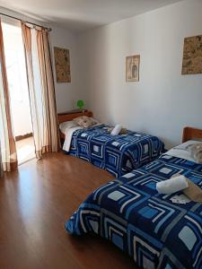 Habitación con 2 camas en una habitación con ventana en Pensión Albergue Matias Locanda, en Sarria