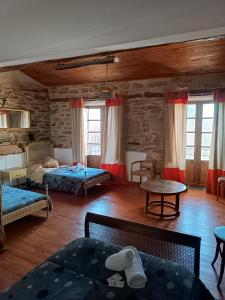 Sala de estar con 2 camas y mesa en Pensión Albergue Matias Locanda, en Sarria